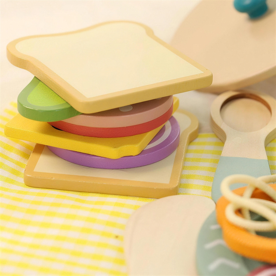 Wooden play sandwich pieces stacked on a plate