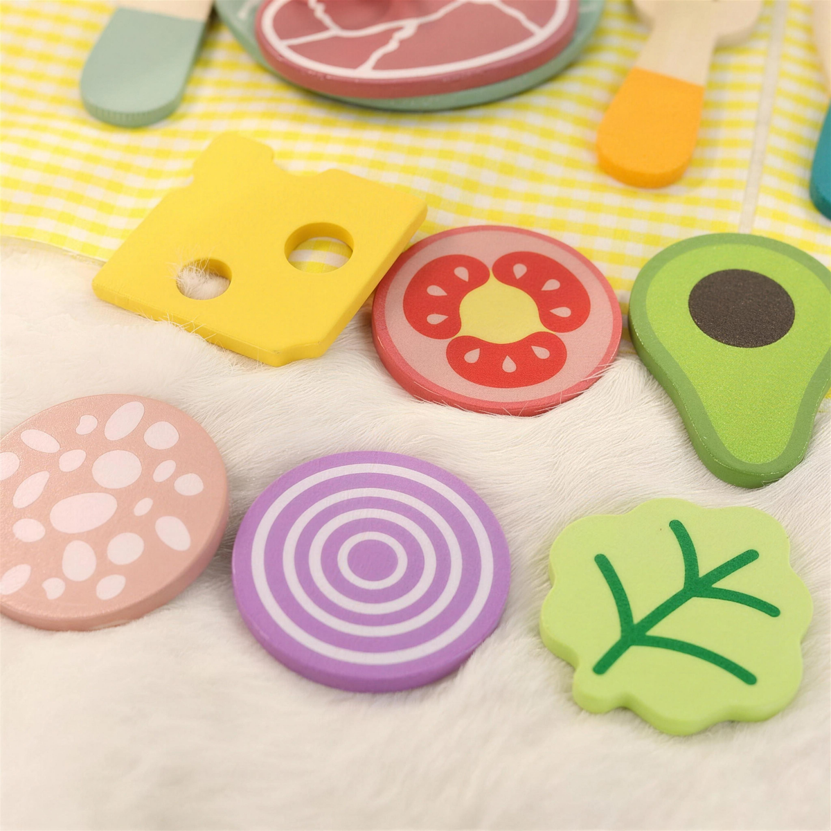 Wooden play food slices including cheese, tomato and avocado